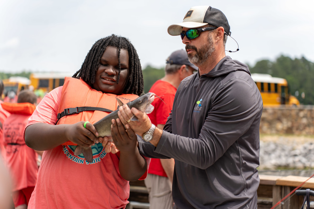 Student holds a fish at Gone Fishing event.