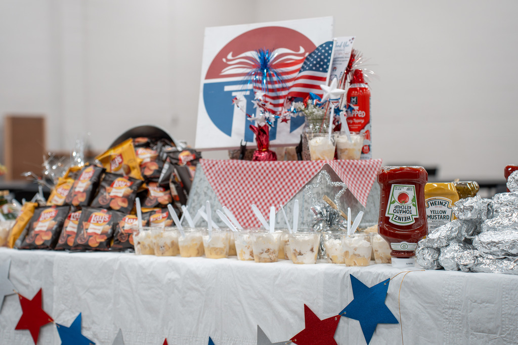 Picture of food, including hotdogs, chips, pudding, and red, white, and blue decorations.