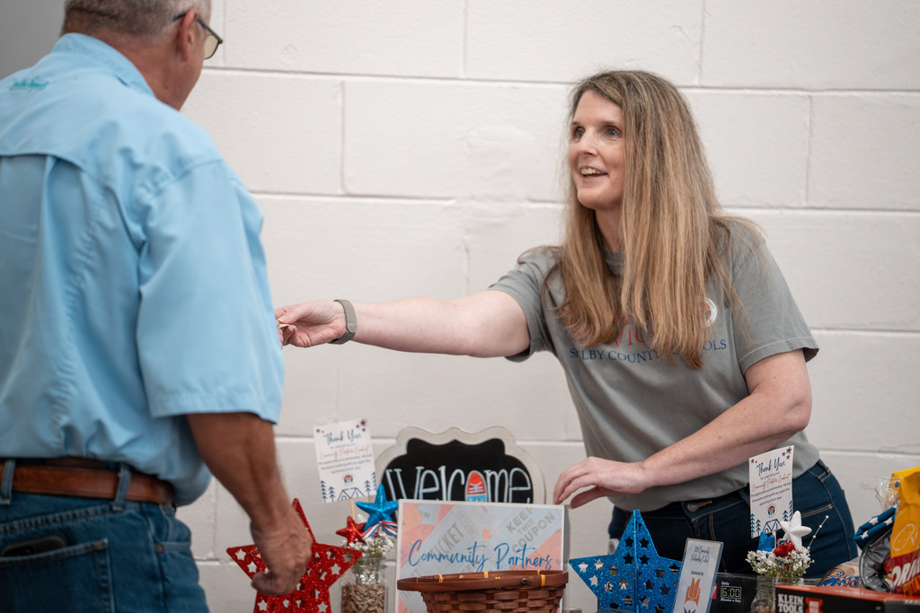 Community Partnership attendee picking up a door price ticket from SCS staff member