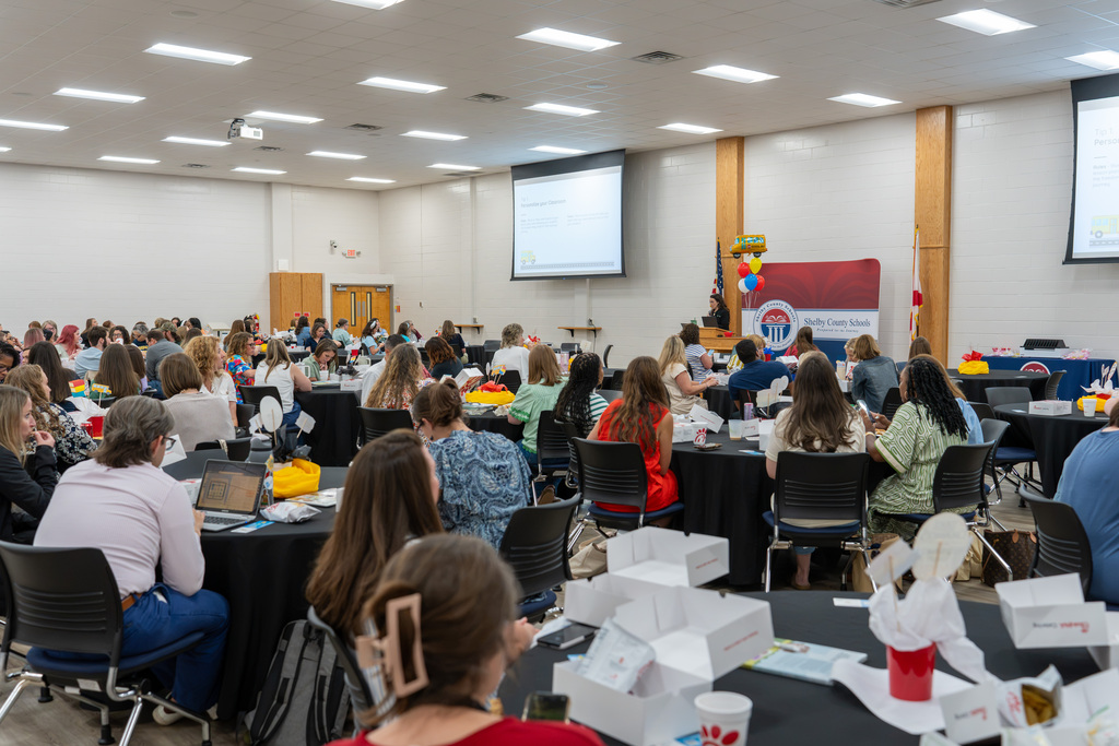 Educators gather for Shelby County Schools' new teacher orientation in a large meeting space.