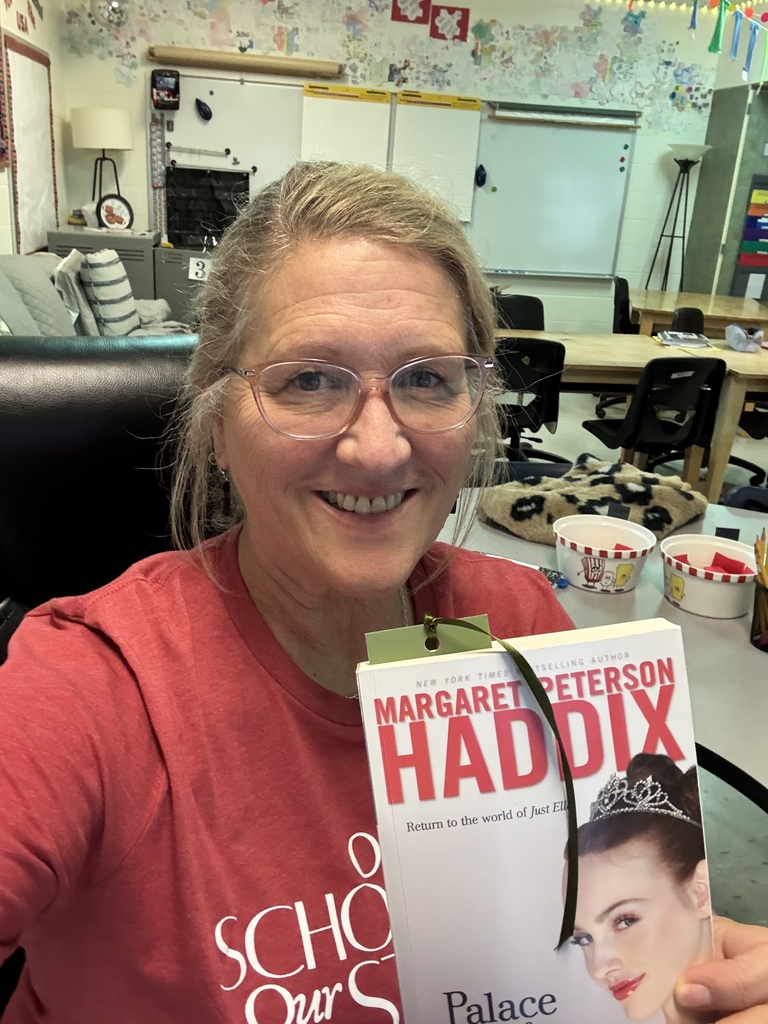 Ms. Pierce reading a book with a princess on the cover 