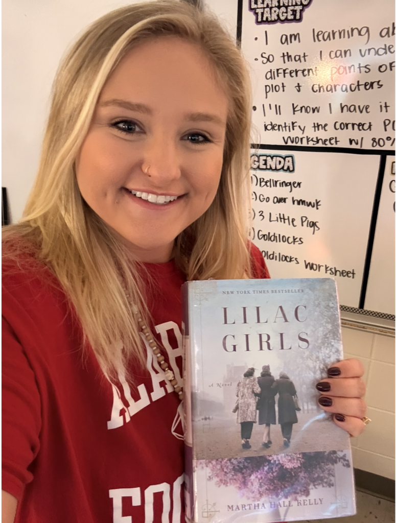a selfie of Mrs. Owens reading a book with three women on the cover 