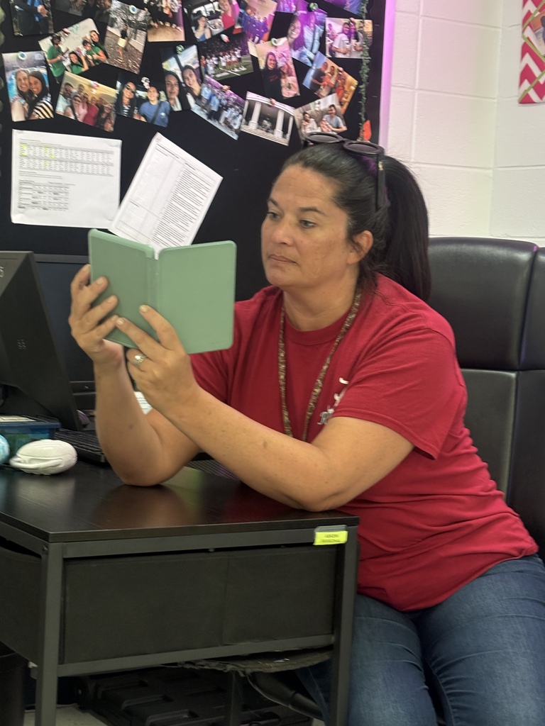 Mrs. Askey reading on her green kindle tablet