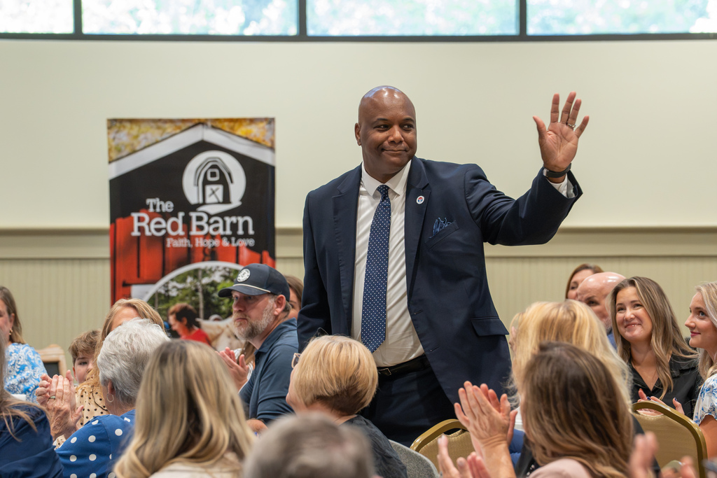 An attendee waves to the crowd during the State of Our Schools event.