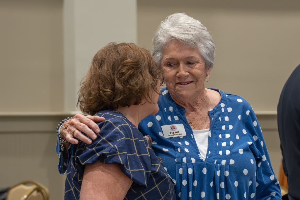 Two women share a warm embrace during the State of Our Schools event.