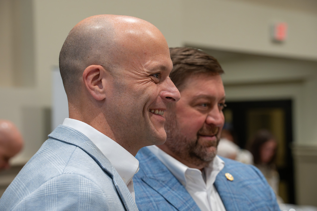 Two attendees smile while watching the State of Our Schools program.