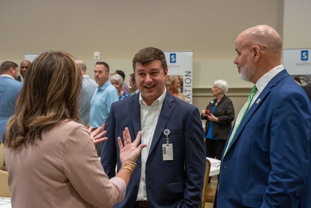 Three attendees converse during the State of Our Schools event.