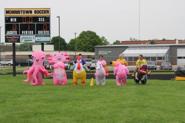 Staff Inflatable Costume Race - octopus, axolotl, chicken, unicorn, flamingo, and t-rex lined up