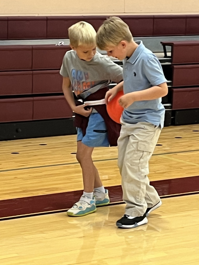 boys balancing ball between them