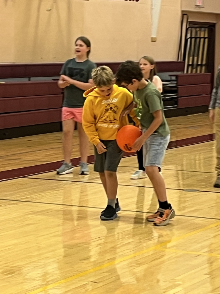 boys balancing ball between them