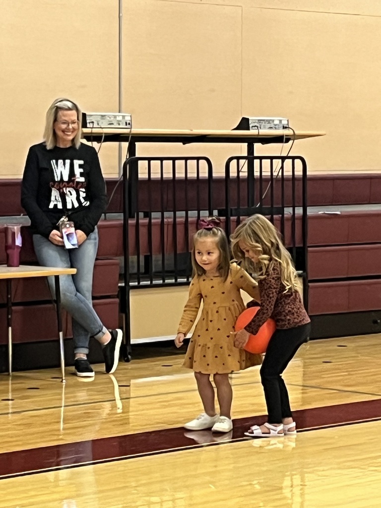 girls balancing ball between them