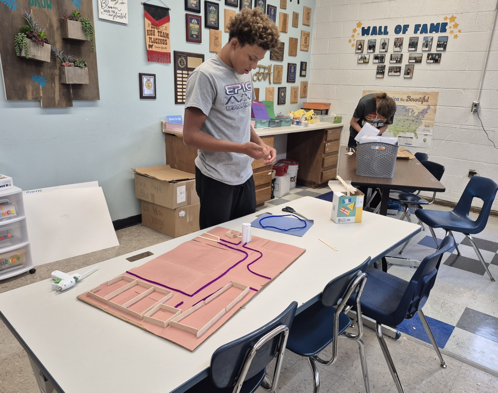 Students using craft materials to build animal facilities