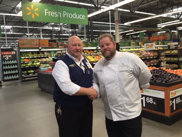 Sheridan food service department representative shakes hands with Walmart representative Sheridan food service department representative shakes hands with Walmart representative