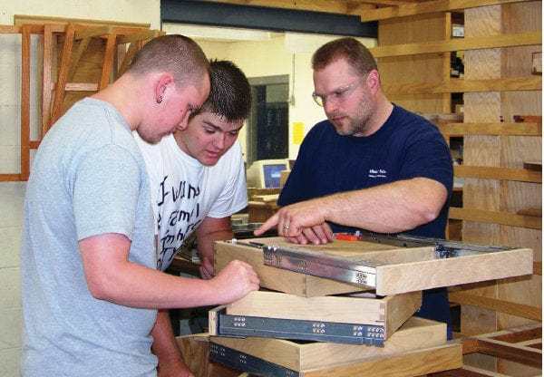 Mark Smith working with two students in the Industrial Technology shop at Shiloh