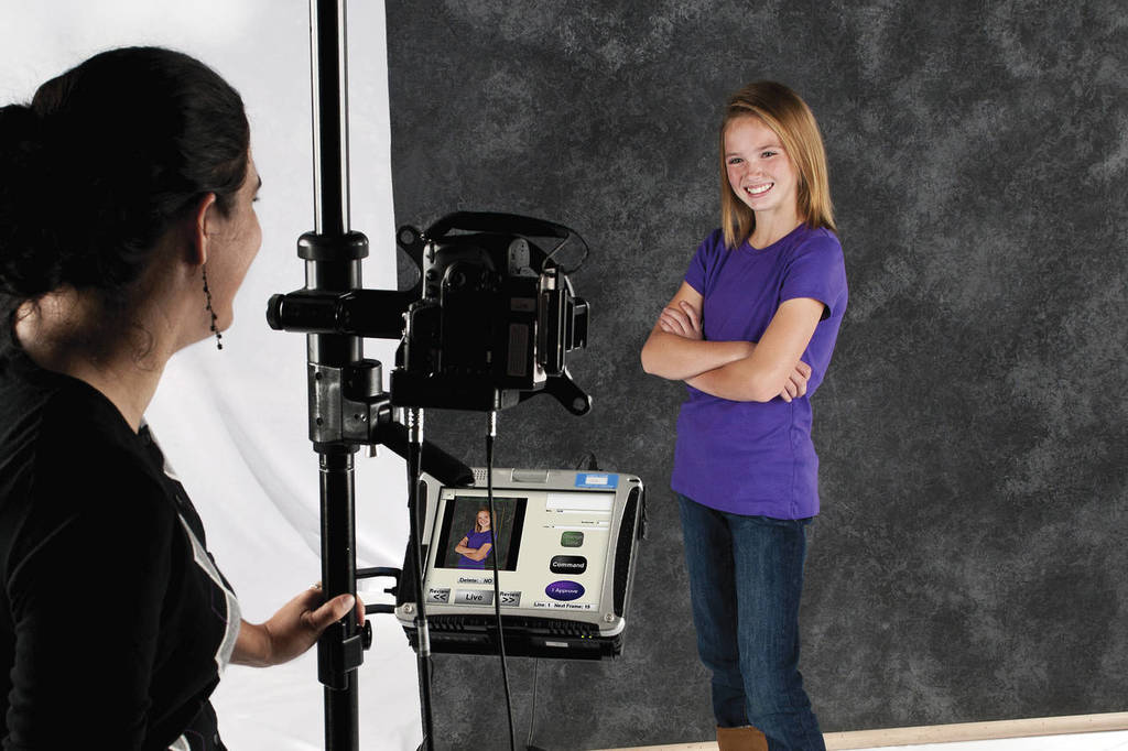 Picture of a photographer photographing a student for a school photo