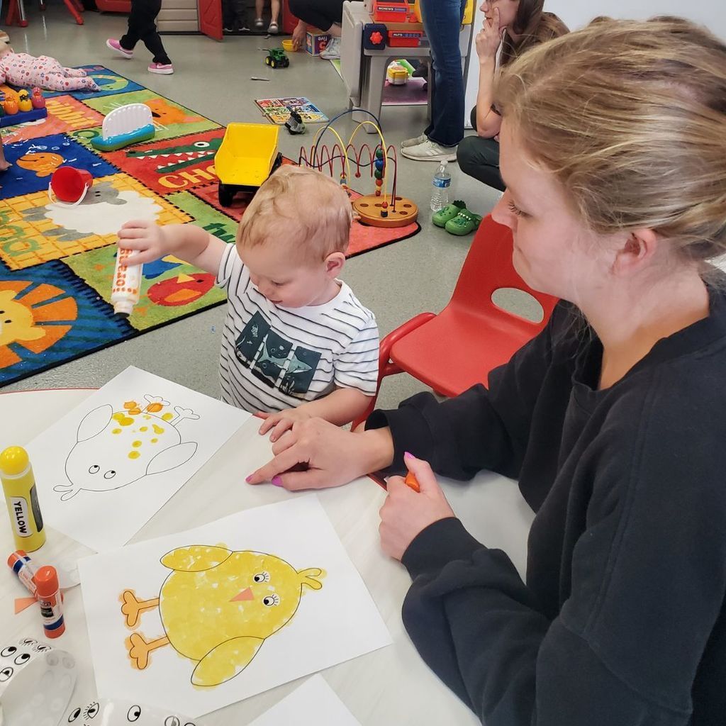 Families and children at PIP group connection in April 2026 observing and interacting with eggs and baby chicks
