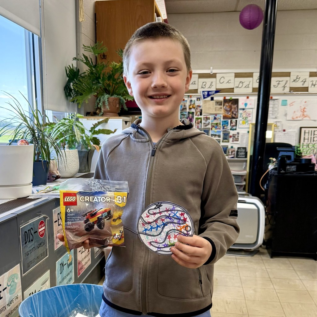Picture of 3rd grade student holding a Lego prize earned for good behavior