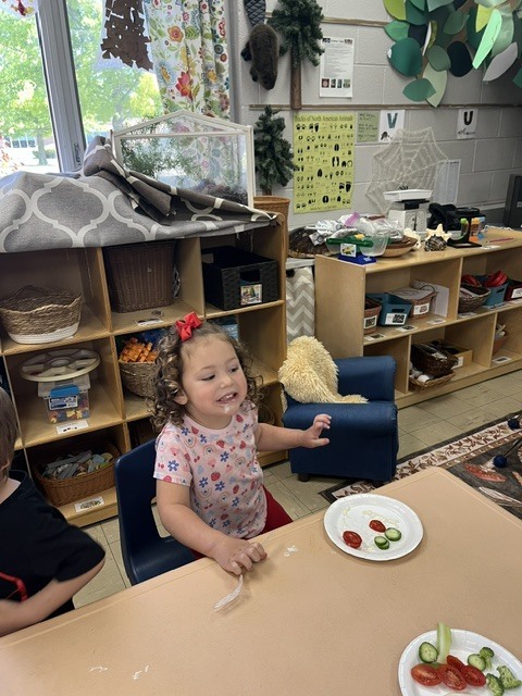 Picture of prekindergarten students eating their vegetables just like plant-eating dinosaurs