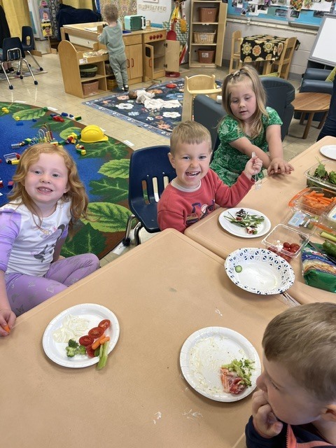 Picture of prekindergarten students eating their vegetables just like plant-eating dinosaurs