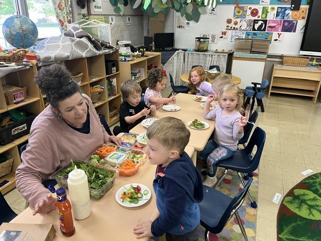 Picture of prekindergarten students eating their vegetables just like plant-eating dinosaurs