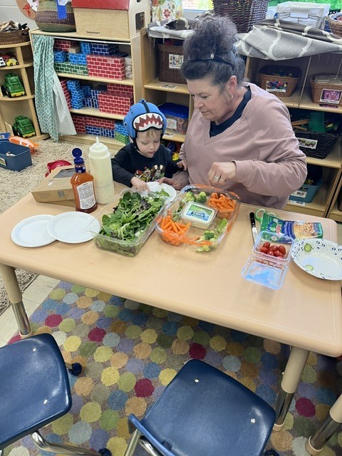 Picture of prekindergarten students eating their vegetables just like plant-eating dinosaurs