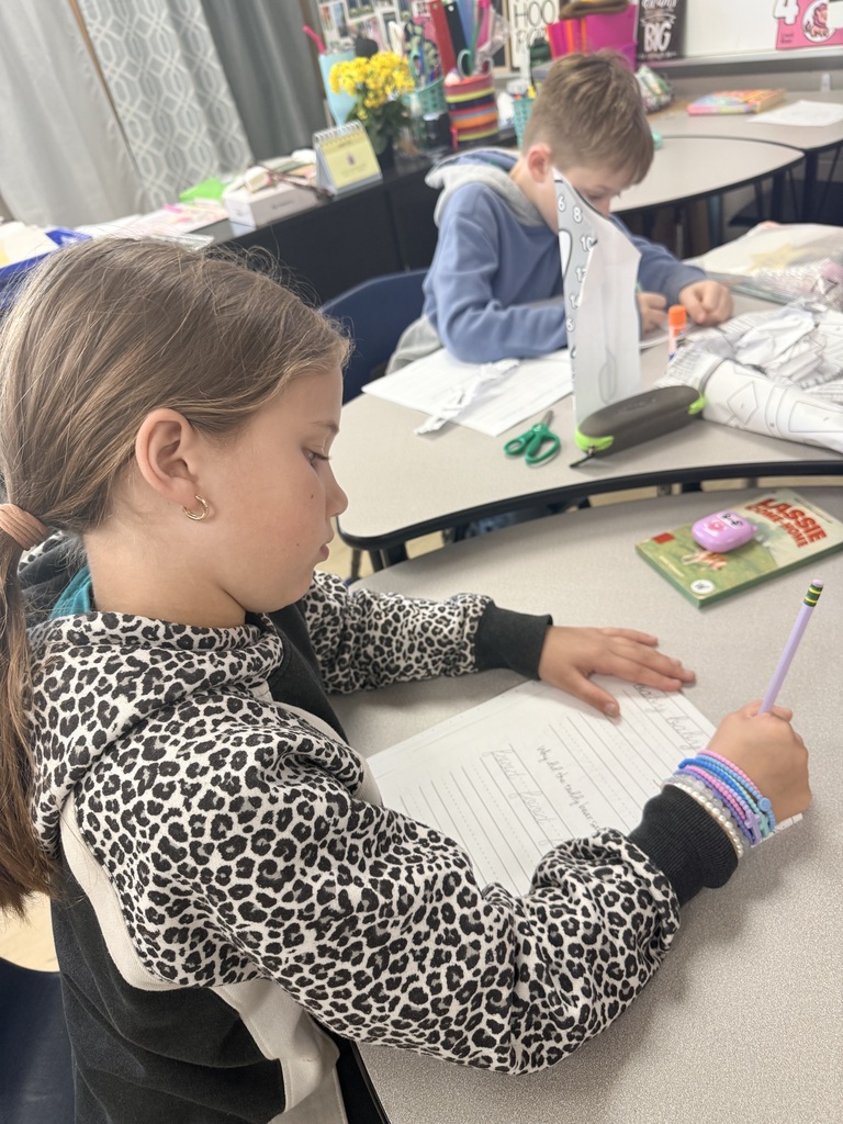 Photo showing two third grade students and the worksheets they are practicing cursive on