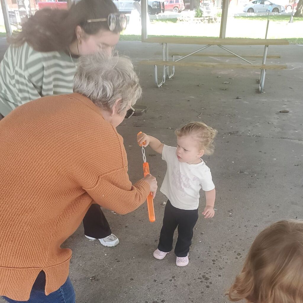 Photos of toddlers and familes on a playground for the May Partnership-in-Parenting group connection