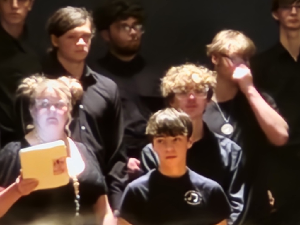 A picture of 4 students dressed in black getting ready to since with Shiloh student Joe pictured in the middle right
