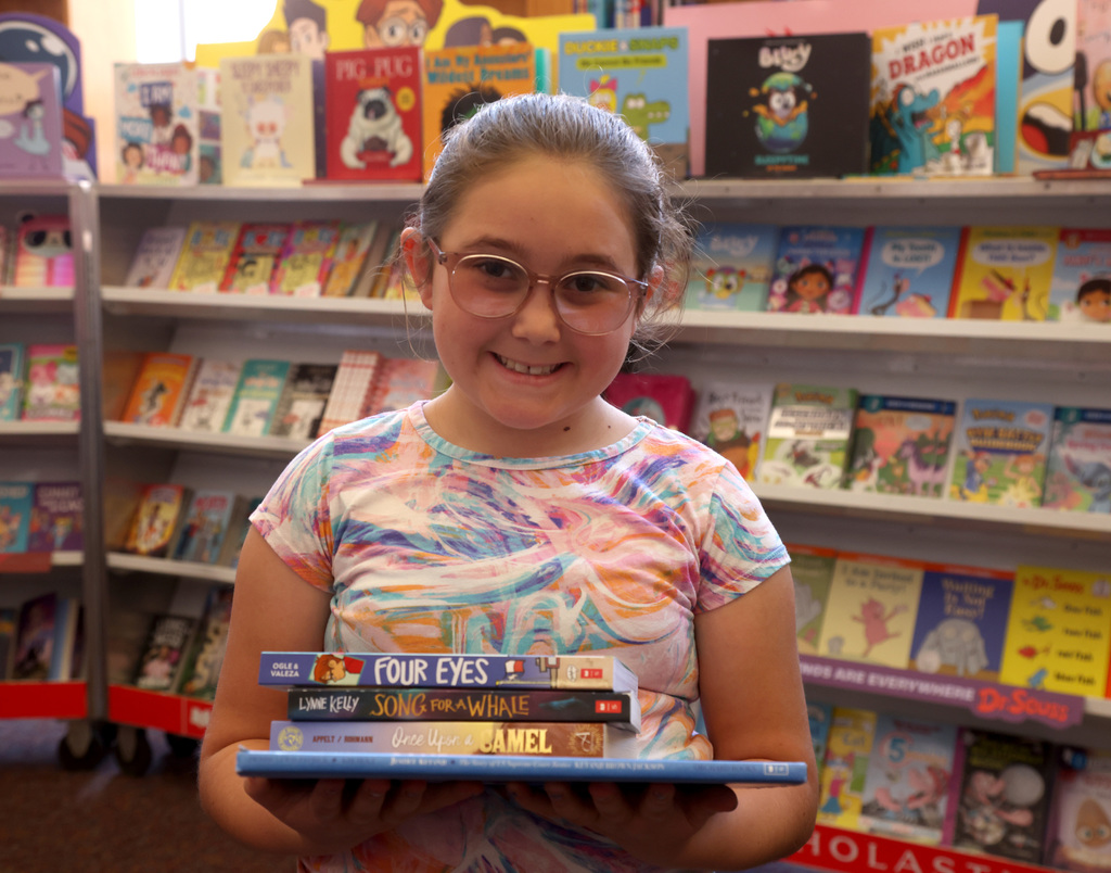 Student holding books at book fair