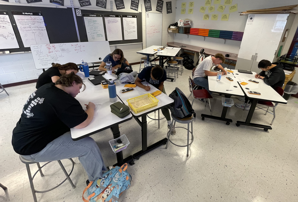 Students in Algebra 1 using white board to work on problems