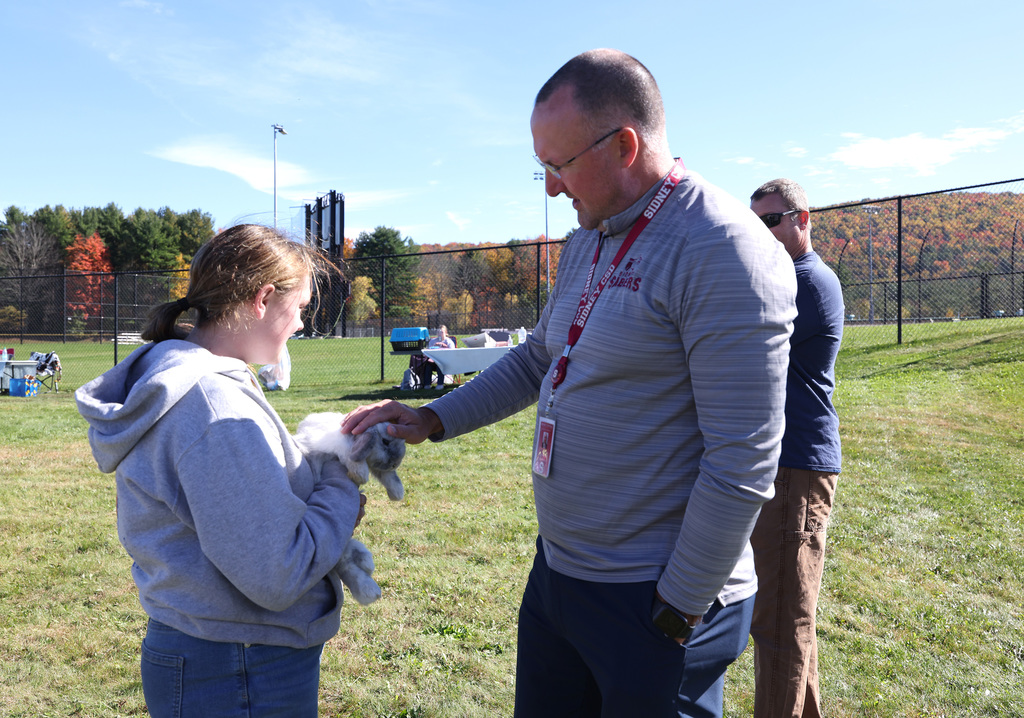 Superintendent Eben Bullock interacting with students and animals at the FFA Fair. 