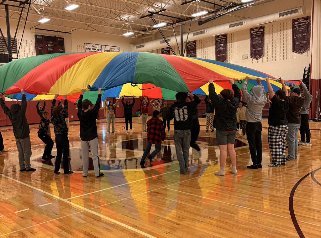 Middle school students taking part in the parachute activity during PE class