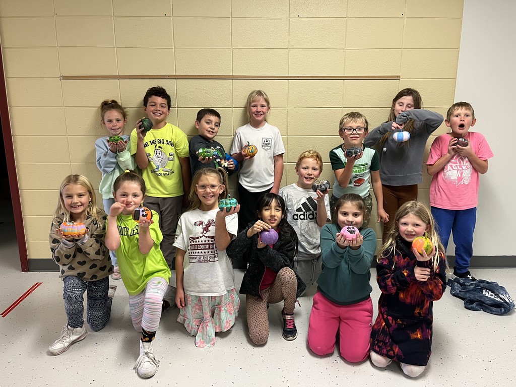 the class holding their pumpkins that they painted