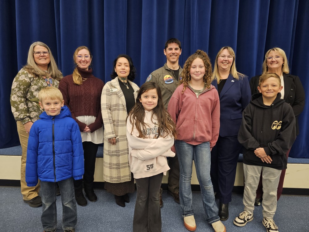 Base and school district leaders pose with students The appearance of U.S. Dept. of War (DoW) visual information does not imply or constitute DoW endorsement.