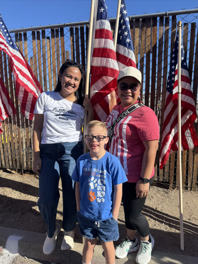 A student and two teachers at the parade of 1,000 flags