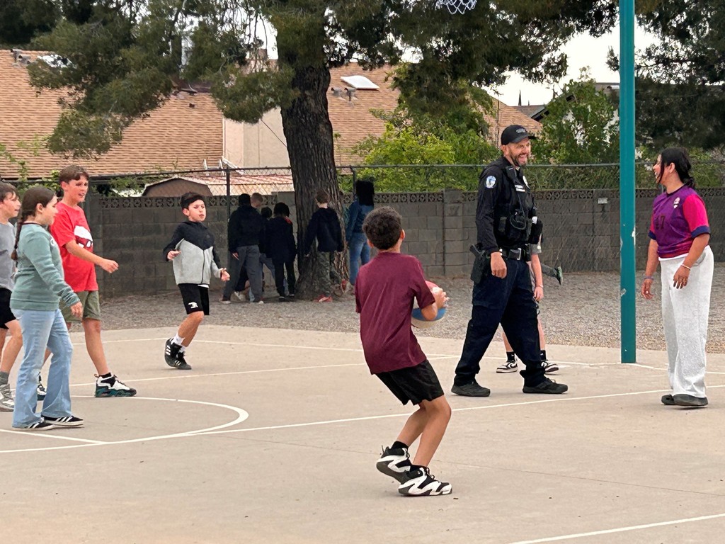 Students take a break from AASA to play basketball with Officer Clark. 