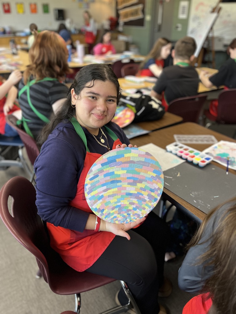 student showing off art project