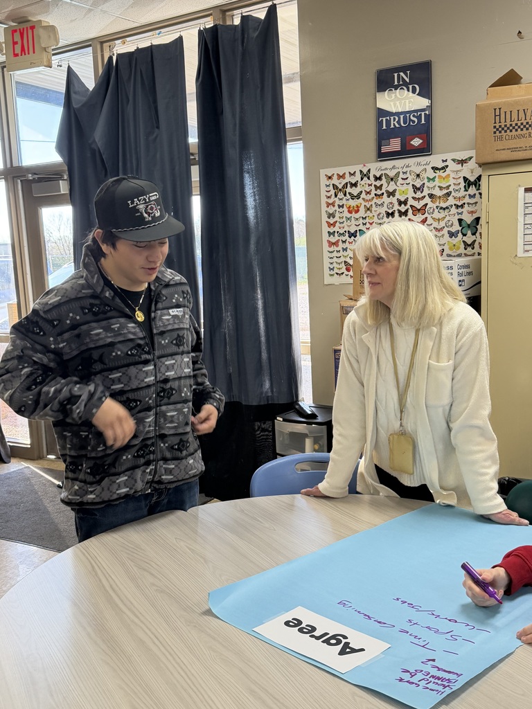 high school students and teacher working on a project