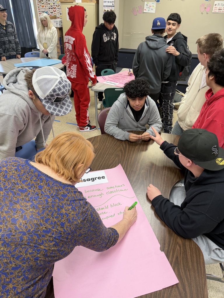 high school students and teacher working on a project