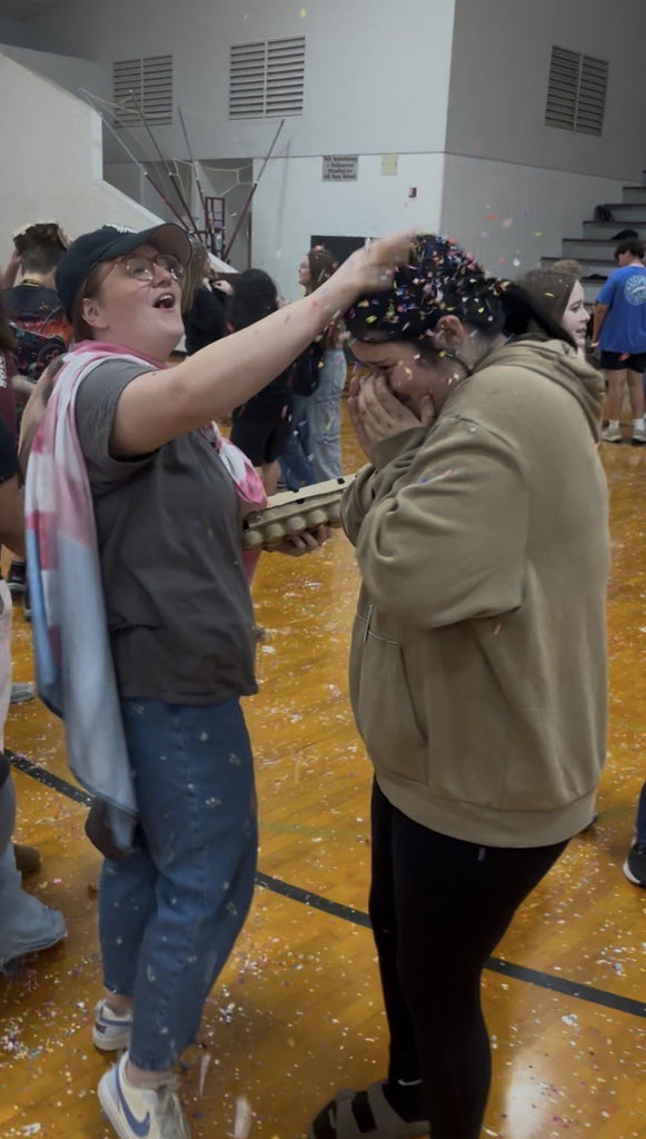 teacher smashing confetti egg on students head