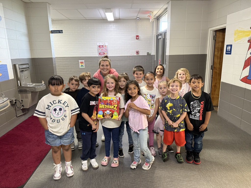 Mrs. Robertson pictured with her class and the game headbanz