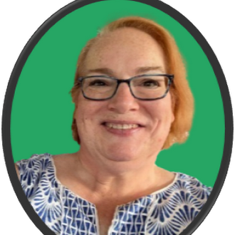 A smiling woman with short hair and glasses, wearing a blue-patterned top, poses in front of a green background.