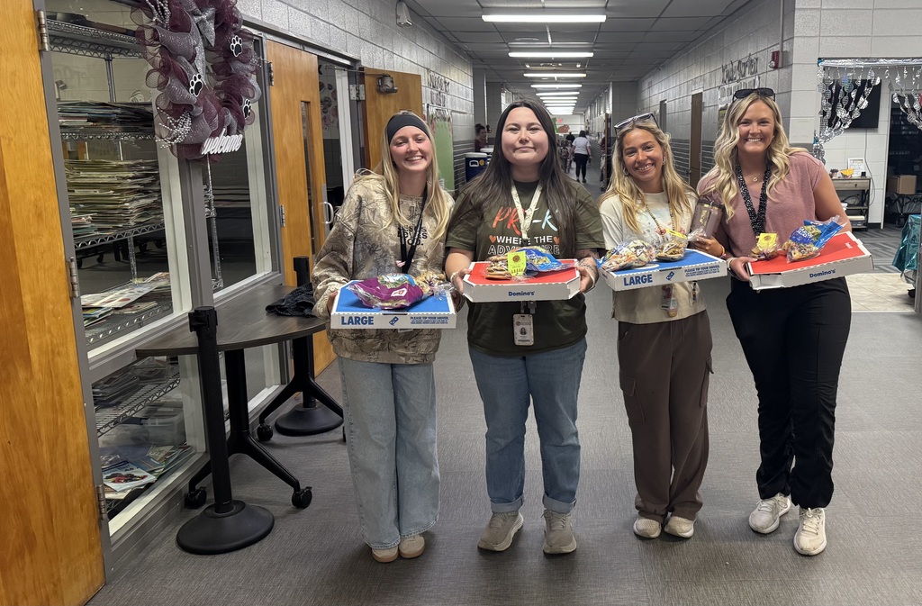 staff members with pizza, salad and cookies