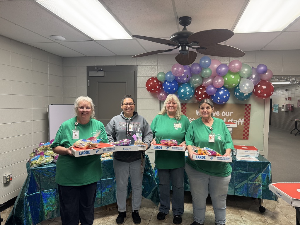 staff members with pizza, salad and cookies