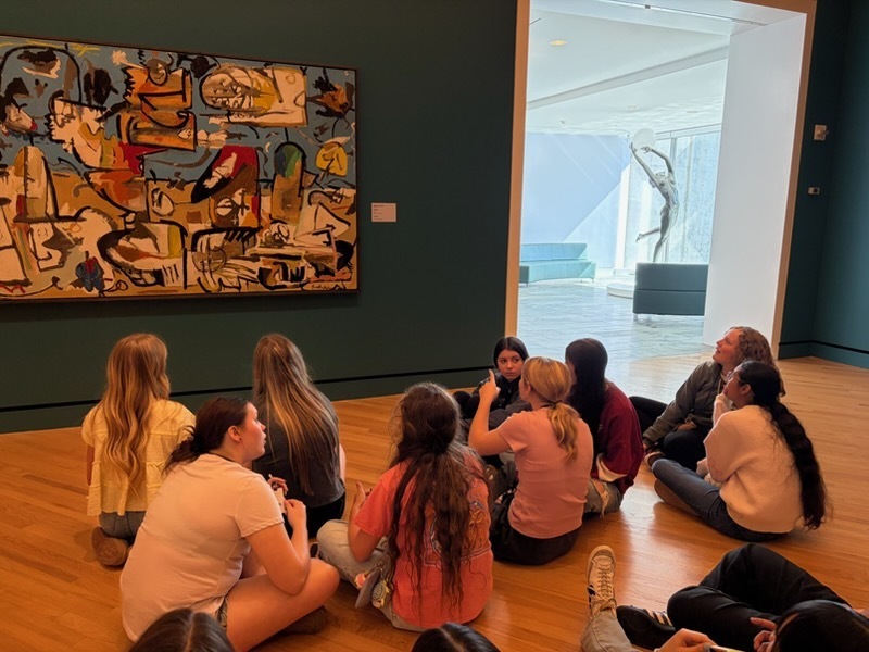 a group of students discussing what they see in a particular painting