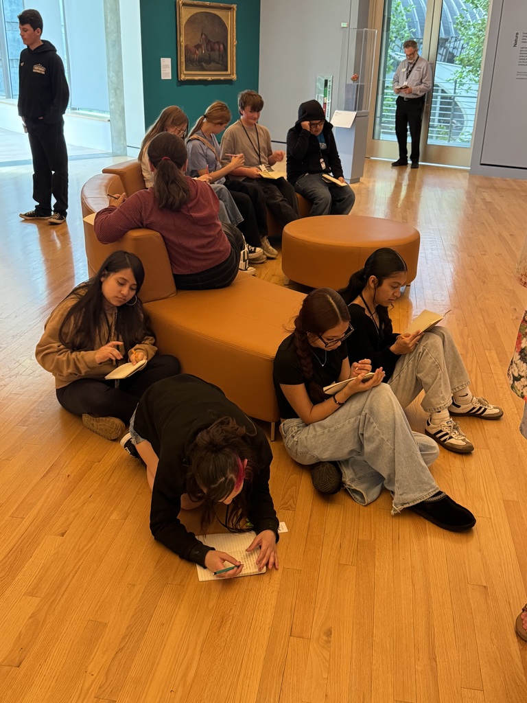 students sitting writing their stories about a painting that spoke to them at Crystal Bridges