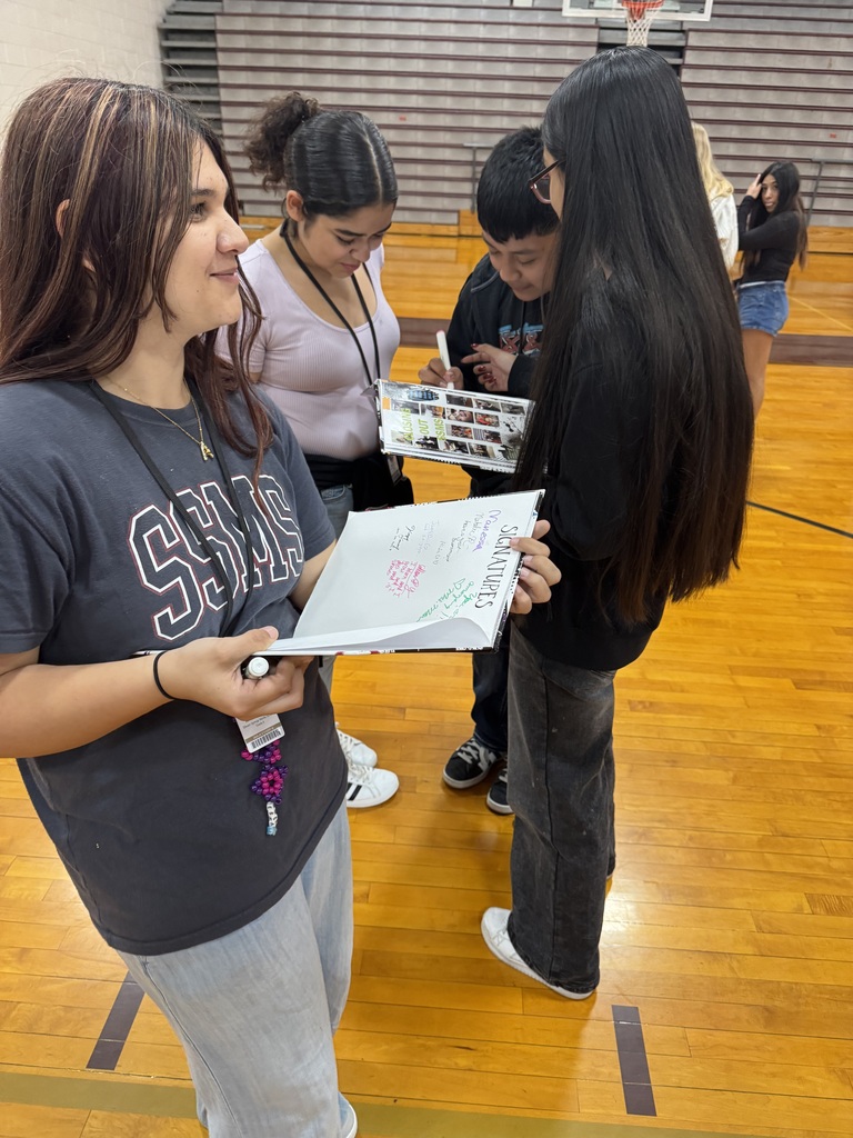 students signing each others yearbooks