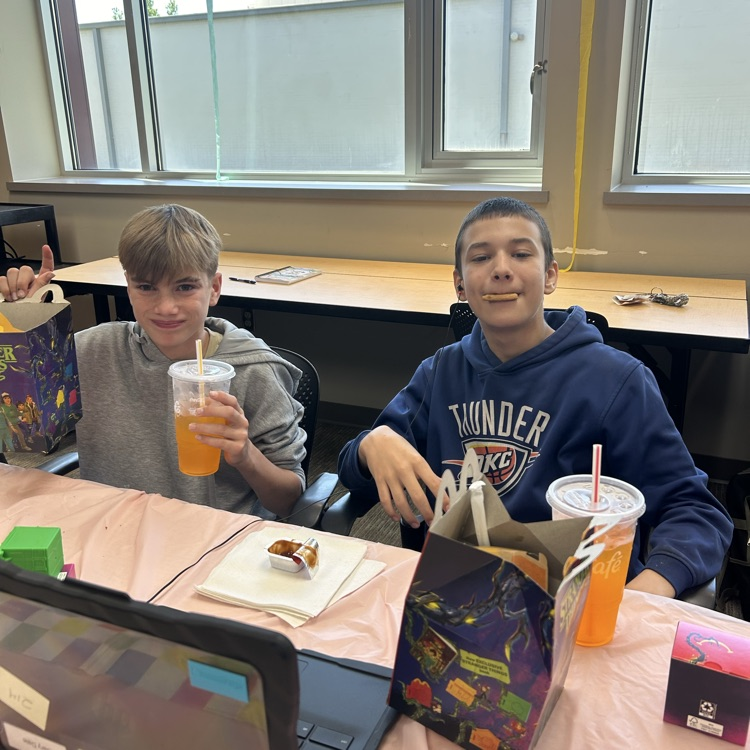Two students enjoying their happy meals that they won.