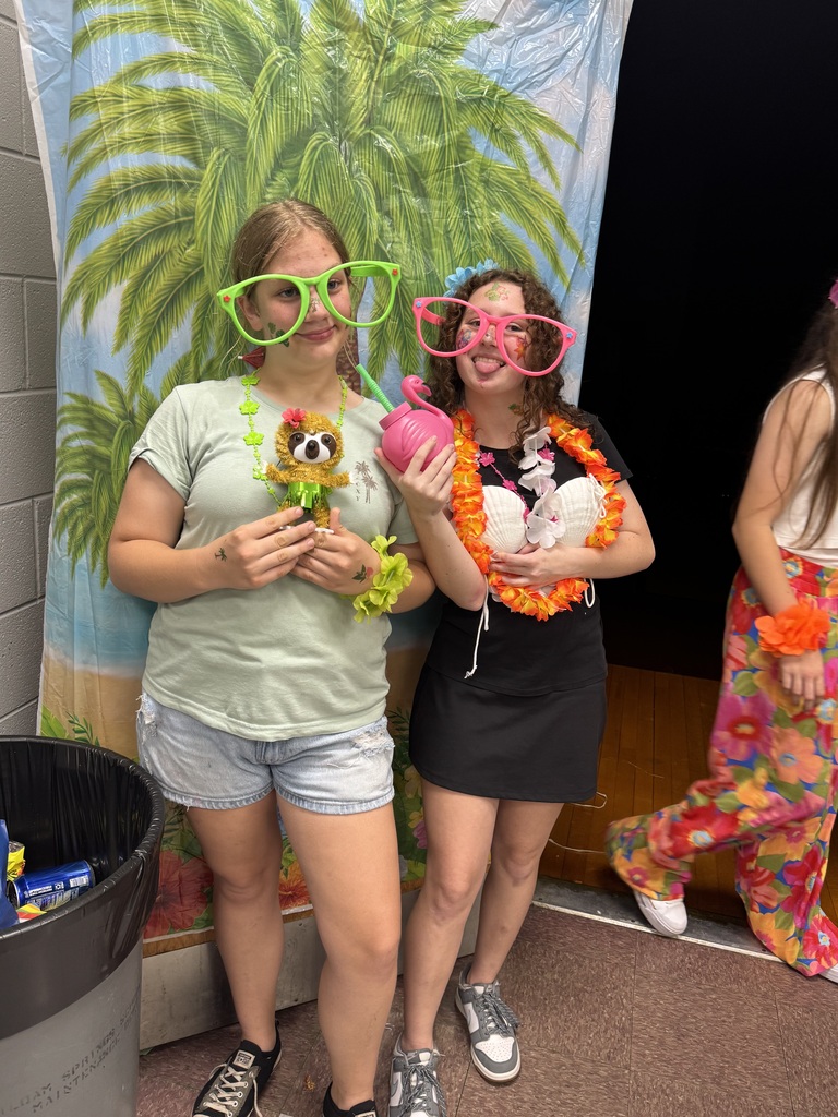 Two students posing for a picture at the 8th grade luau. 