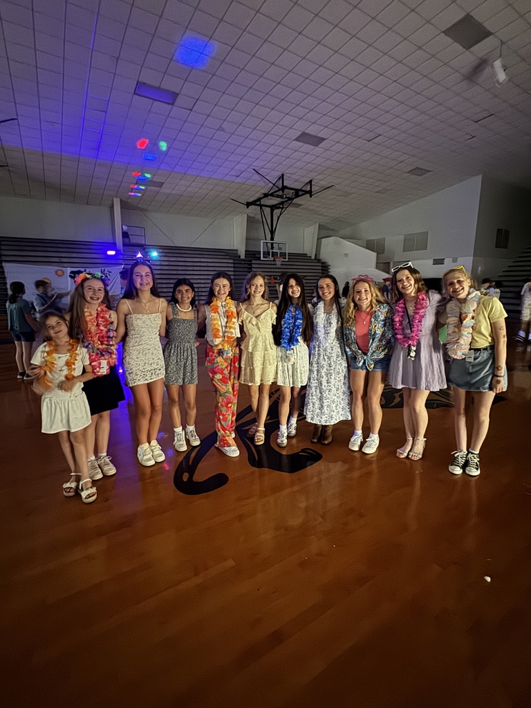 A group of students posing for a picture at the 8th grade luau.
